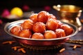 Traditional Indian food, sweet Gulab Jamun balls in a metal plate with cinnamon sticks