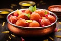 Traditional Indian food, sweet Gulab Jamun balls with mint leaves in a metal plate