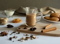 Traditional Indian masala tea with spices. Anise, star anise, cinnamon, pepper, milk, biscuits. White and gray background Royalty Free Stock Photo