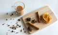 Traditional Indian masala tea with spices. Anise, star anise, cinnamon, pepper, milk. White background. Wooden plank. Top view Royalty Free Stock Photo