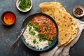 Traditional Indian Punjabi dish Dal makhani with lentils and beans in black bowl served with basmati rice, naan flat