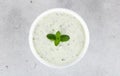 Traditional Indian raita with cucumber, herbs and dahi yogurt on gray background. Greek tzatziki sauce in a white bowl. Royalty Free Stock Photo