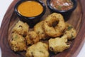 traditional indian snack food, crispy deep fried vada and chutneys in a serving plate