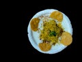 Traditional Indian street food papdi chaat in a white bowl isolated on a black background