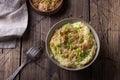 Traditional Irish dish colcannon, mashed potatoes with cabbage and green onions, on top of crispy fried cabbage topping with nuts