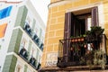 Traditional iron balcony with pots hanging from the railing in Lavapies neighborhood in Madrid