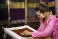 Traditional Isan Thai silk weaving. Asian woman embroidering golden thread on silk. Yong woman are Sewing silk Royalty Free Stock Photo