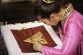 Traditional Isan Thai silk weaving. Asian woman embroidering golden thread on silk. Yong woman are Sewing silk Royalty Free Stock Photo