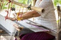 Traditional Isan Thai silk weaving. old woman hand weaving silk in traditional way at manual loom. Thailand. Selective focus Royalty Free Stock Photo