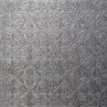 Traditional islamic rhythmic arabesque pattern in form of embossing on metal. Textured gray-silver background