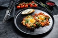 Traditional Israeli Cuisine dishes Shakshuka. Fried egg with tomatoes and paprika. Black background. Top view Royalty Free Stock Photo