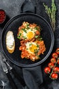 Traditional Israeli Cuisine dishes Shakshuka. Fried egg with tomatoes and paprika. Black background. Top view Royalty Free Stock Photo