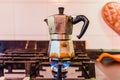 Traditional Italian aluminum coffee pot, on fire in a kitchen