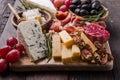 Traditional italian antipasto plate. Assorted cheeses on wooden cutting board. Brie cheese, cheddar slices, gogonzola, walnuts Royalty Free Stock Photo