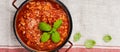 Traditional italian Bolognese sauce in saucepot an old dark wooden background. Top view, copy space Royalty Free Stock Photo