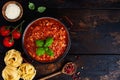 Traditional italian Bolognese sauce in saucepot an old dark wooden background. Top view Royalty Free Stock Photo