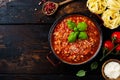 Traditional italian Bolognese sauce in saucepot an old dark wooden background. Royalty Free Stock Photo