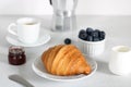 Italian breakfast: pastries, jam, berries, milk, geyser coffee maker on a white background, side view Royalty Free Stock Photo