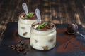 Traditional Italian dessert tiramisu decorated with cocoa powder and green mint in glass jar Royalty Free Stock Photo