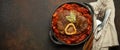 Traditional Italian dish Ossobuco all Milanese made with cut veal shank meat with vegetable tomato sauce served in black Royalty Free Stock Photo