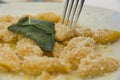 A traditional Italian dish: Pumpkin Gnocchi with Parmesan cheese and a decorative sage leaf