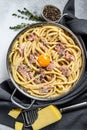 Traditional italian dish spaghetti carbonara with bacon in a cream sauce in a skillet. Gray background. Top view Royalty Free Stock Photo