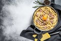 Traditional italian dish spaghetti carbonara with bacon in a cream sauce in a skillet. Gray background. Top view. Copy space Royalty Free Stock Photo