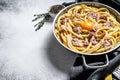 Traditional italian dish spaghetti carbonara with bacon in a cream sauce in a skillet. Gray background. Top view. Copy space Royalty Free Stock Photo