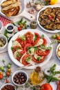 Traditional Italian food, caprese salad made of sliced fresh tomatoes, mozzarella cheese and basil  served on a white plate Royalty Free Stock Photo