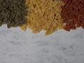 Traditional italian farfalle pasta in national flag tricolor style on gray marble background with copy space.