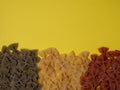 Traditional italian farfalle pasta in national flag tricolor style on yellow background with copy space