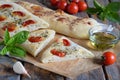 Traditional Italian Focaccia with tomatoes, basil, garlic and sumach. Homemade pastry. Flat bread. Organic flatbread. Rustic style Royalty Free Stock Photo