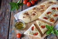 Traditional Italian Focaccia with tomatoes, basil, garlic and sumach. Homemade pastry. Flat bread. Organic flatbread. Rustic style Royalty Free Stock Photo