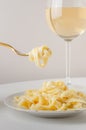 Traditional Italian pasta - Fetuccini Alfredo on a white table with golden appliances