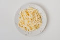 Traditional Italian pasta - Fetuccini Alfredo on a white table with golden appliances