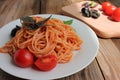 Traditional Italian pasta and ingredients on the white plate on rustic wooden table background. Long spaghetti with tomato sauce, Royalty Free Stock Photo