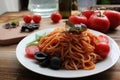 Traditional Italian pasta and ingredients on the white plate on rustic wooden table background. Long spaghetti with tomato sauce, Royalty Free Stock Photo