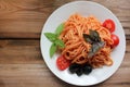 Traditional Italian pasta and ingredients on the white plate on rustic wooden table background. Long spaghetti with tomato sauce, Royalty Free Stock Photo