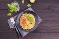 Traditional Italian pasta spaghetti with tomatoes, tomato sauce, basil on a dark wooden background. Royalty Free Stock Photo