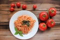 Traditional Italian pasta with tomato sauce and basil on the white plate,. Fresh tomatoes in the wine and cherry tomatoes on rusti Royalty Free Stock Photo