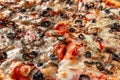 Traditional Italian pizza background with cheese, olives, tomato, onion, pepperoni sausage close-up