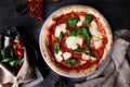 Traditional Italian pizza Margarita. Basil leaves and tomato sauce. Metal plate for serving food. Vertical photo Royalty Free Stock Photo