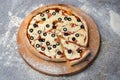 Traditional Italian pizza with tomato sauce, black olives, ham and mozzarella cheese on wooden board Royalty Free Stock Photo