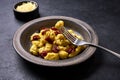 Traditional Italian potato gnocchi pricked on a fork lying on plate with dish