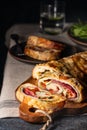 Traditional Italian Stromboli stuffed with cheese, salami, red pepper and spinach. Photo in a dark style. Royalty Free Stock Photo