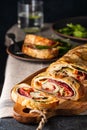 Traditional Italian Stromboli stuffed with cheese, salami, red pepper and spinach. Photo in a dark style. Royalty Free Stock Photo