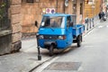 Traditional Italian three wheel car Piaggio Ape staying parked on the street.