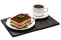 Traditional Italian Tiramisu dessert square portion on ceramic plate and cup of fresh espresso coffee on stone serving