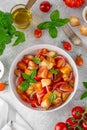 Traditional italian tomato salad panzanella with red onion, fresh basil and croutons in a bowl. Summer salad