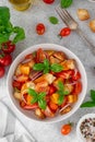 Traditional italian tomato salad panzanella with red onion, fresh basil and croutons in a bowl. Summer salad